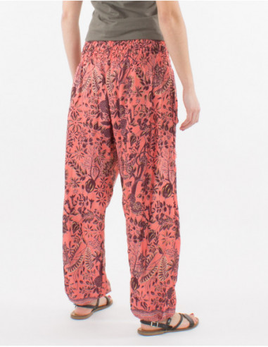 Pantalon femme style Aladin baba cool resserré aux chevilles imprimé fleurs et feuilles rose saumon