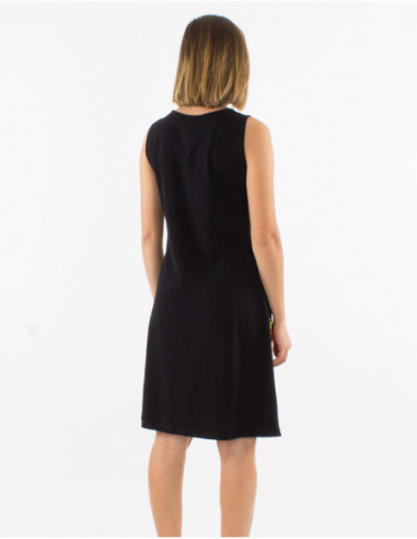 Back of short sleeveless black cotton dress with printed baba cool rosettes colors